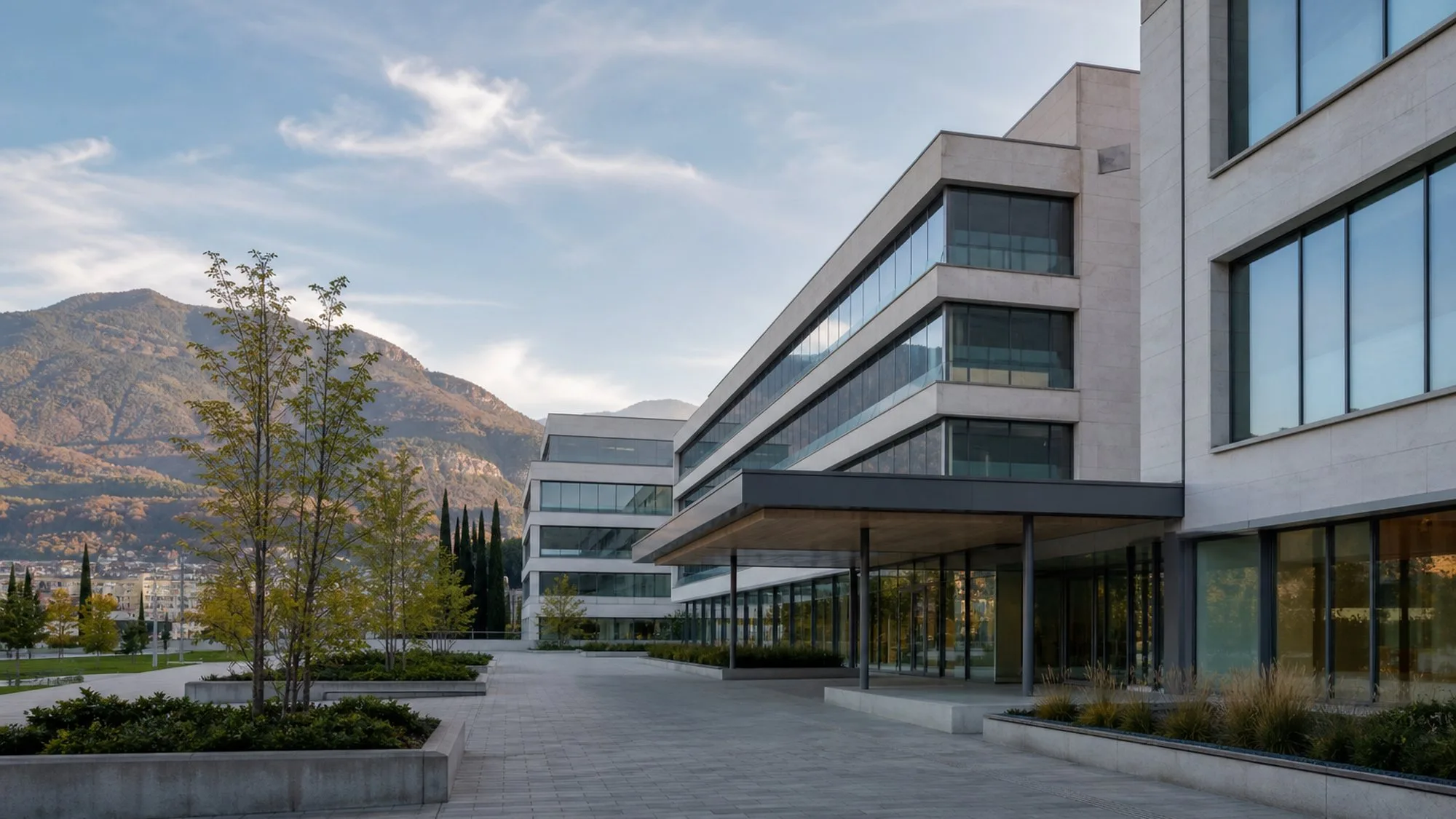 Illustrative generated image of a modern research campus in a Ticino valley setting, representing the Bellinzona biomedical research context of IOR. Not a photograph of the Institute of Oncology Research building.